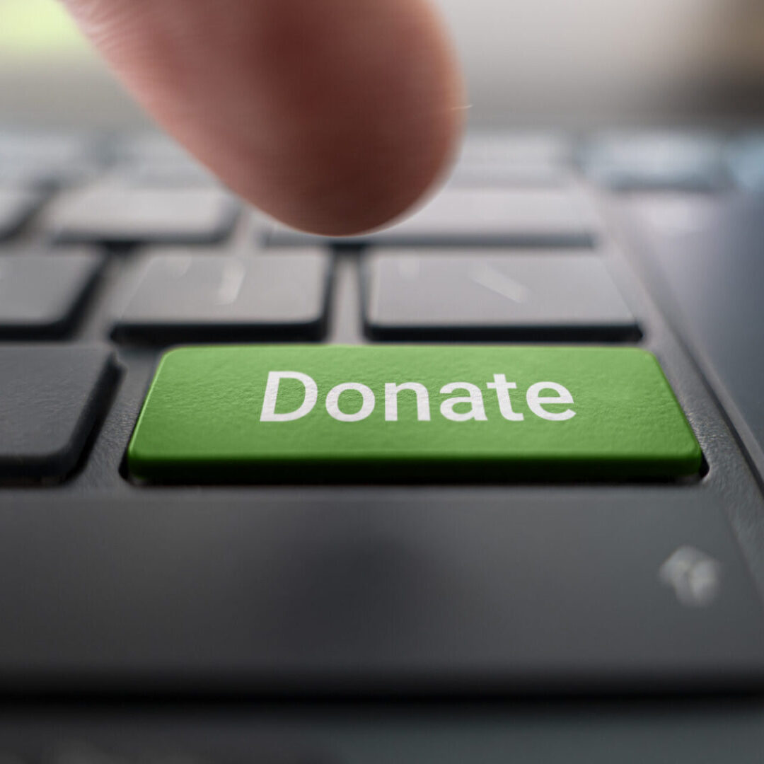 Finger pressing green "Donate" keyboard button.
